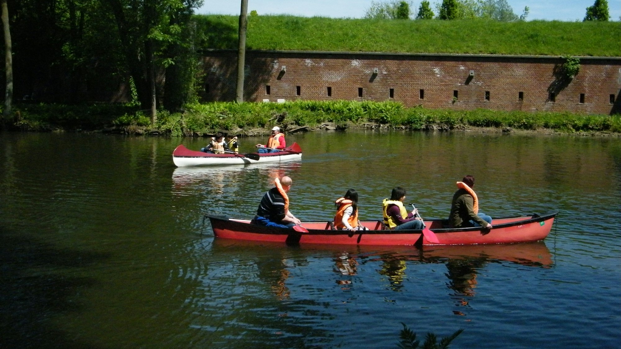 Kanufahrer in zwei Booten auf einem Gewässer.