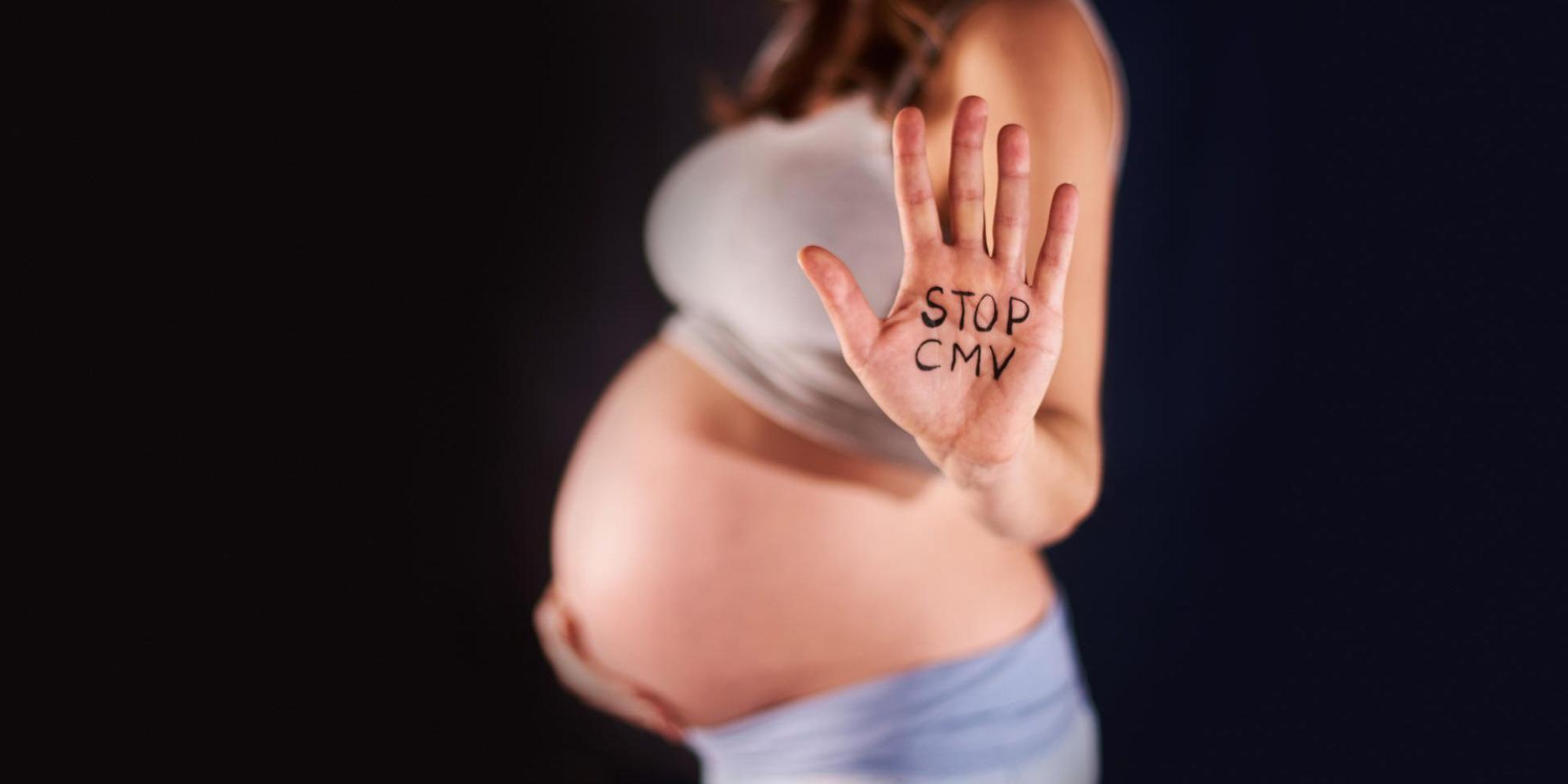 Hand einer Schwangeren mit dem Schriftzug "Stopp CMV"