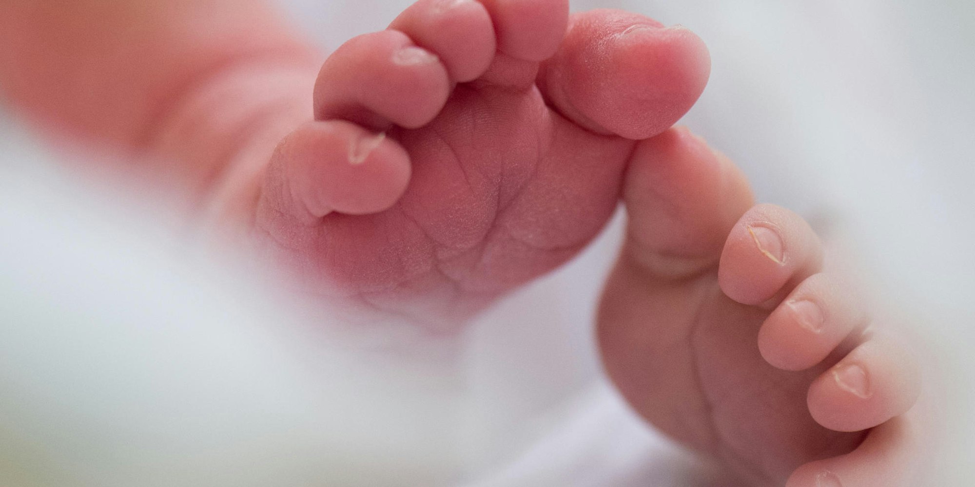 Babyfüße von Neugeborenem dpa