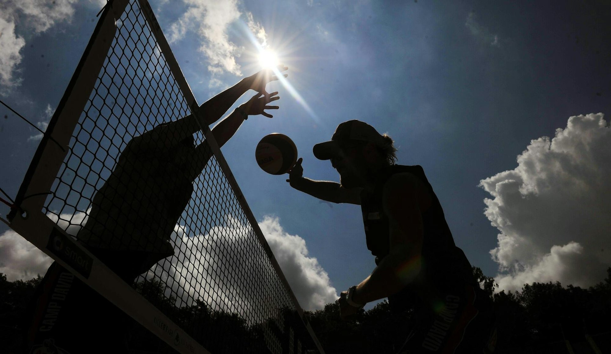 Beachvolleyball gegen Sonne am Netz symbol