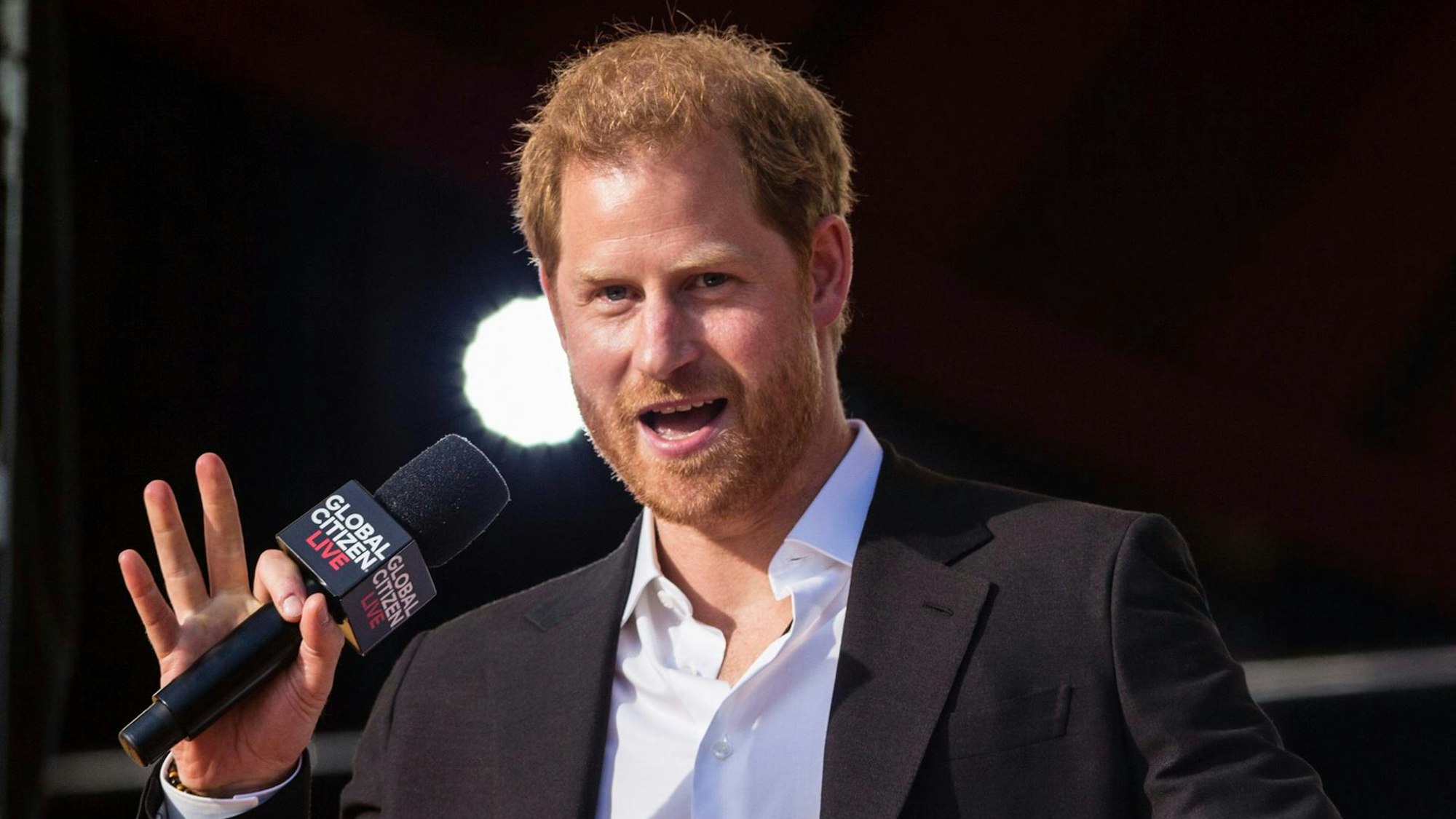 Prinz Harry auf der Bühne mit einem Mikro.