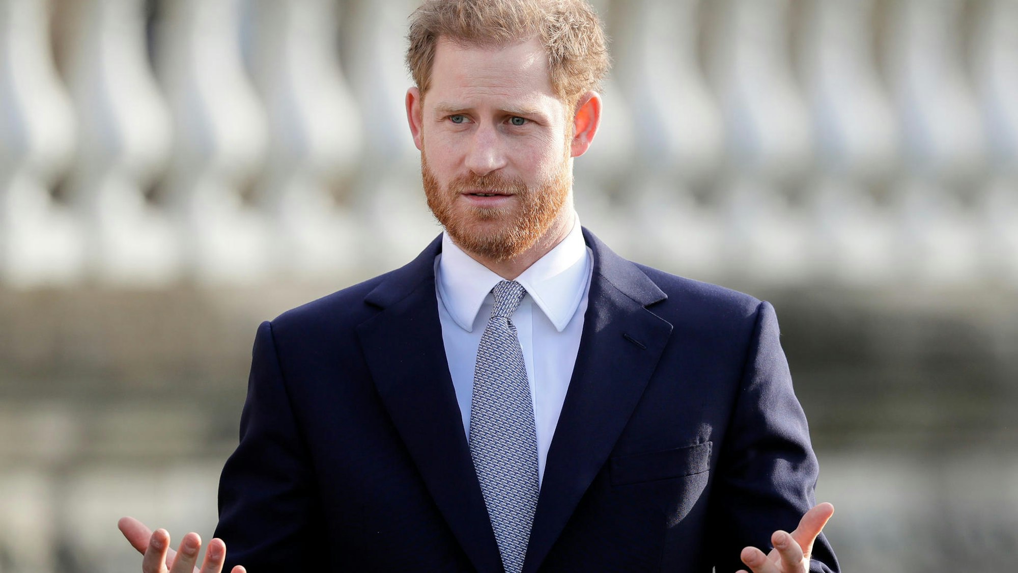 Prinz Harry hebt fragend die Arme.