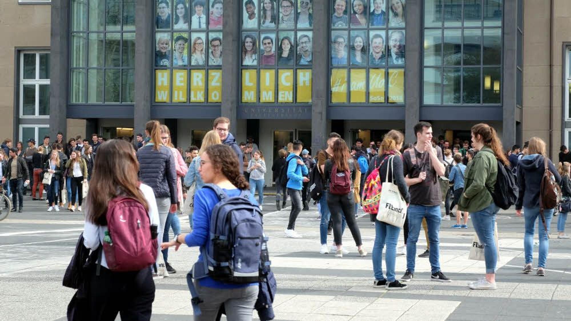 Studenten laufen vor dem Hauptgebäude der Universität zu Köln.