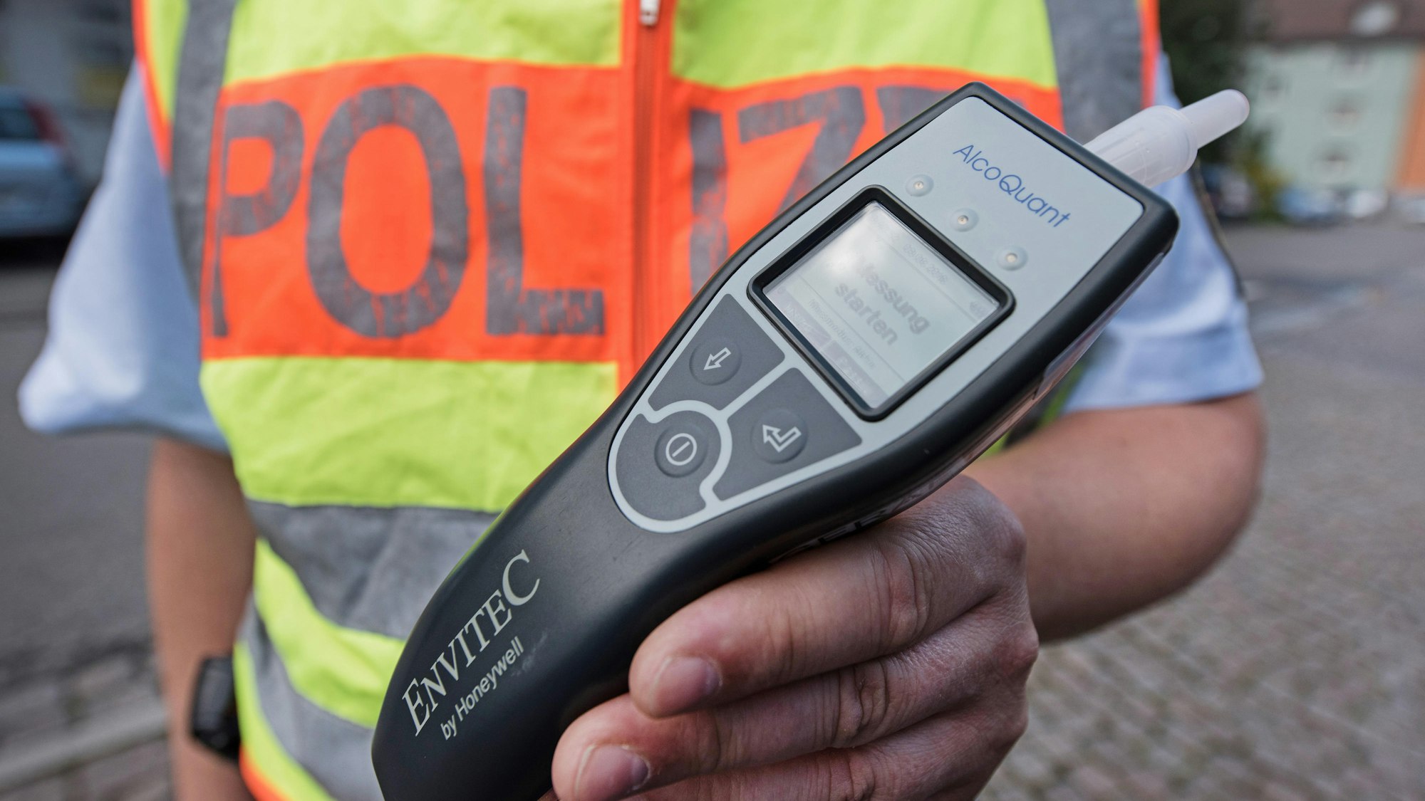 Ein Polizeibeamter zeigt ein Alkoholtestgerät.