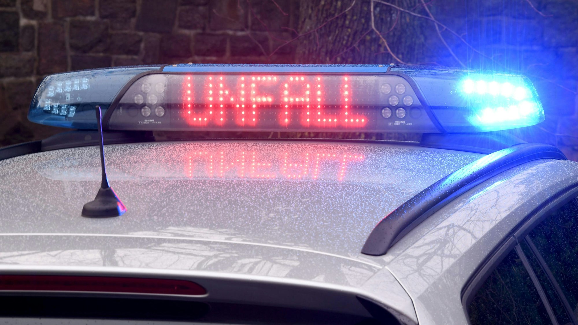 Auf dem Dach eines Polizeiautos leitet Blaulicht und der rote Schriftzug „Unfall“.