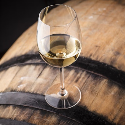 Ein Weinglas steht auf einem Fass