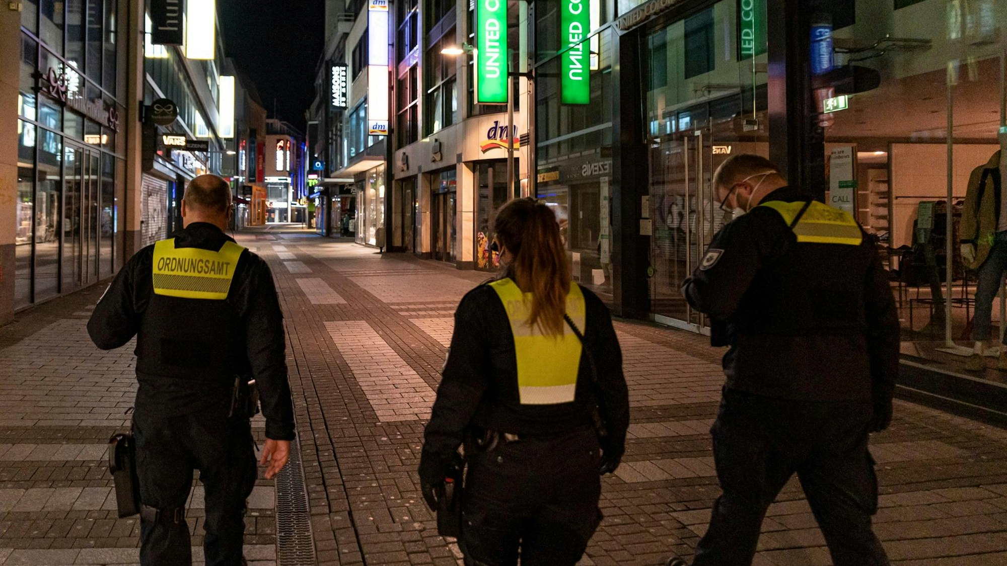 Drei Einsatzkräfte des Kölner Ordnungsamts auf Streife während der nächtlichen Ausgangssperre im Frühjahr 2021.