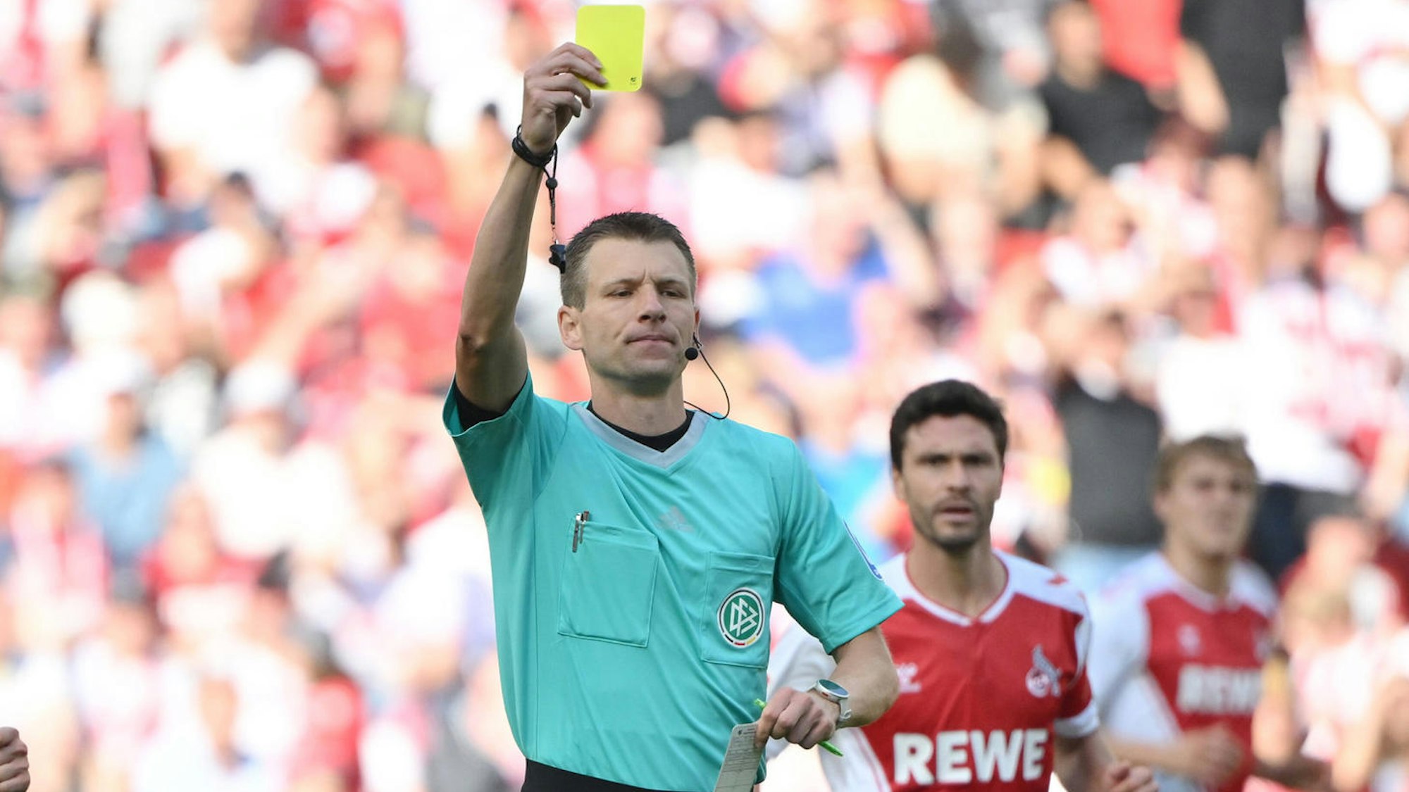 Schiedsrichter Benjamin Cortus zückt im FC-Spiel gegen Union Berlin 2022 eine Gelbe Karte.