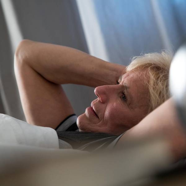 Frau liegt wach im Bett