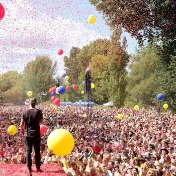 Das Publikum und die Bühne bei „Jeck im Sunnesching”. Es fliegt Konfetti und Luftballons steigen auf.