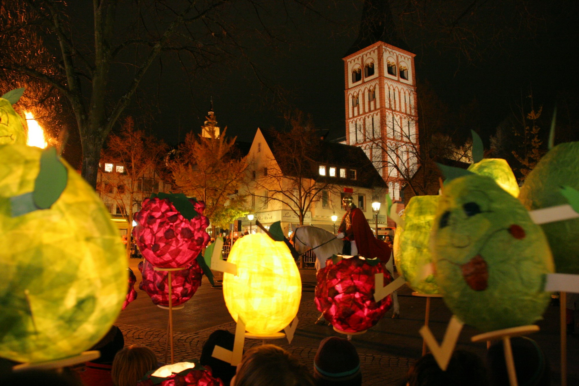 Kinder mit bunten Laternen stehen auf dem Siegburger Marktplatz.