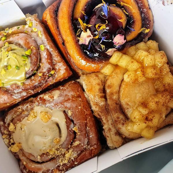 Lecker angerichtete und verzierte Zimtschnecken liegen in einer To-Go-Box.